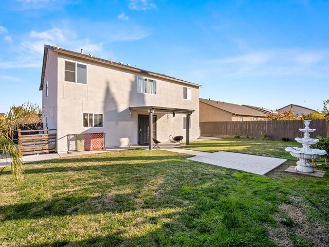 rear view of property with a yard and a patio area