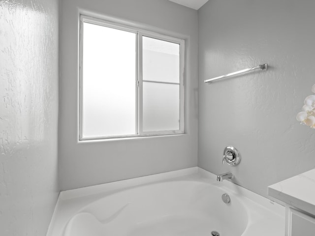 bathroom featuring plenty of natural light and a bathtub