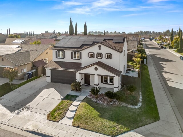 view of front of home with a front yard and solar panels