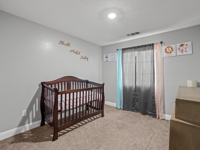 carpeted bedroom featuring a crib