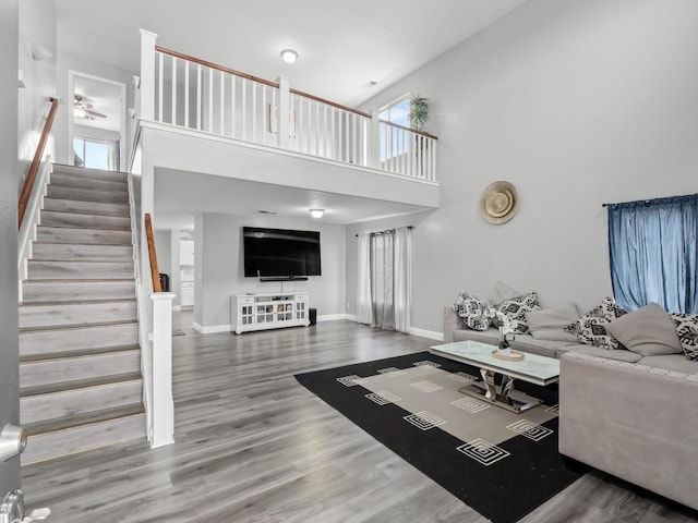 living room with hardwood / wood-style floors and a towering ceiling