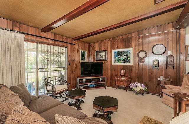 living room with light carpet, beamed ceiling, and wood walls