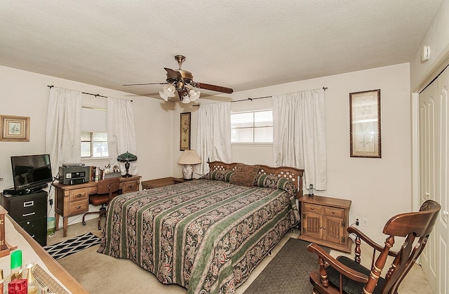 carpeted bedroom featuring ceiling fan, a textured ceiling, and a closet