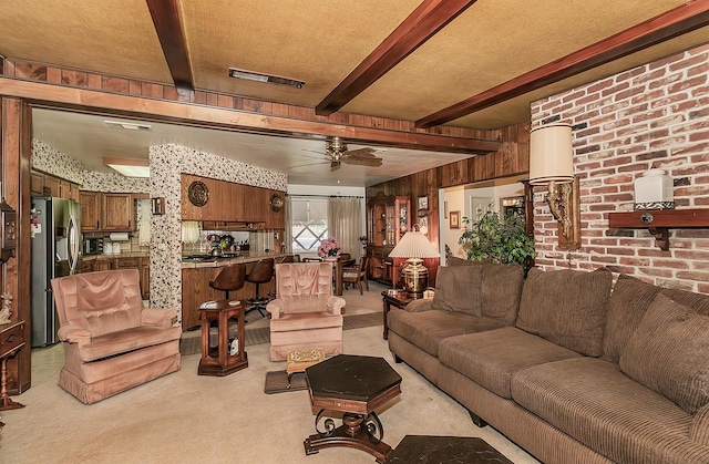 carpeted living room featuring beam ceiling, ceiling fan, and wood walls