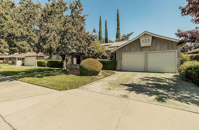 view of front of property with a front yard, solar panels, and a garage