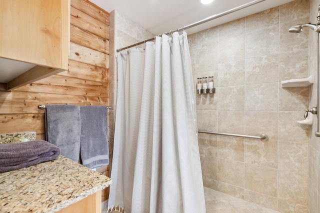 bathroom featuring walk in shower and wood walls