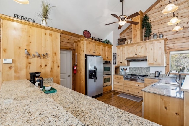 kitchen with appliances with stainless steel finishes, light brown cabinetry, sink, log walls, and hanging light fixtures