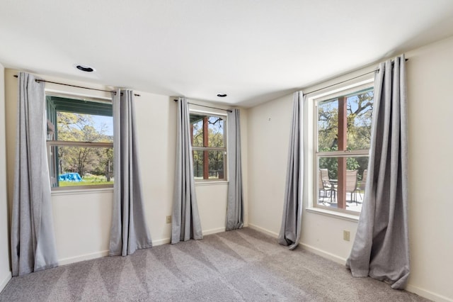 unfurnished room featuring light colored carpet and a healthy amount of sunlight