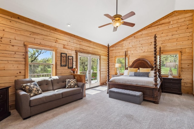 carpeted bedroom with access to exterior, vaulted ceiling, ceiling fan, and wooden walls