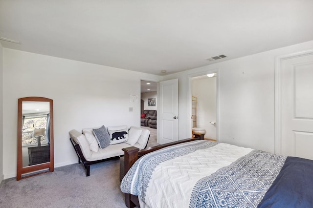 carpeted bedroom featuring ensuite bath