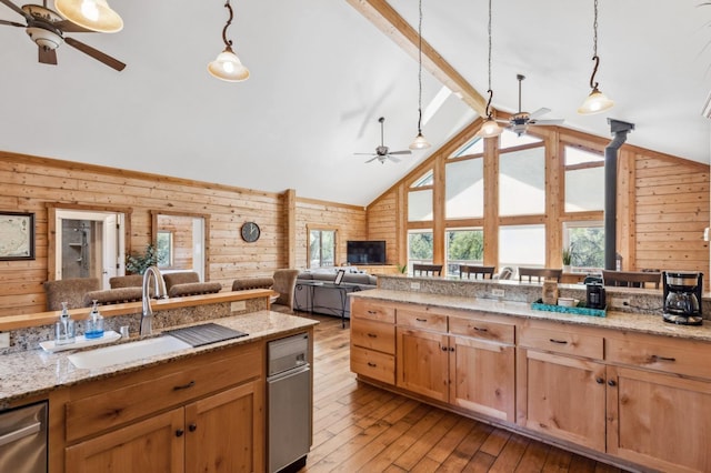 kitchen featuring pendant lighting, wooden walls, and sink