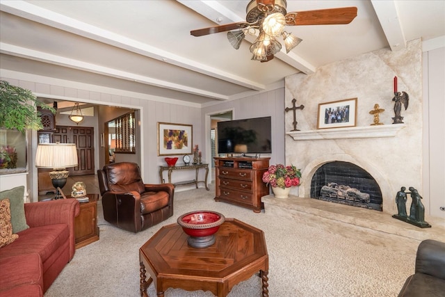 living room with beamed ceiling, light carpet, and a large fireplace