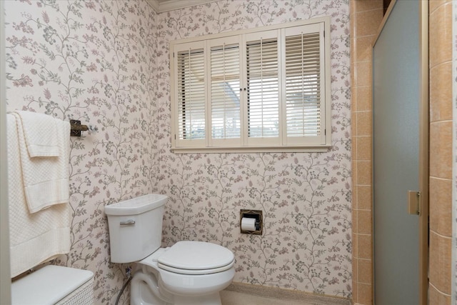 bathroom featuring walk in shower, crown molding, and toilet