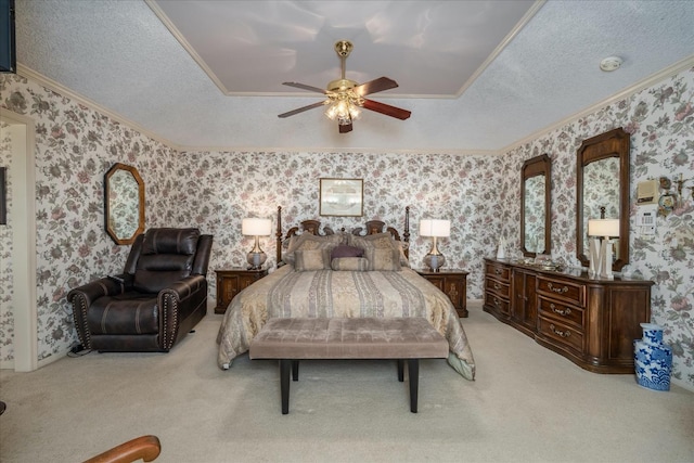 carpeted bedroom with a textured ceiling, ceiling fan, crown molding, and a tray ceiling