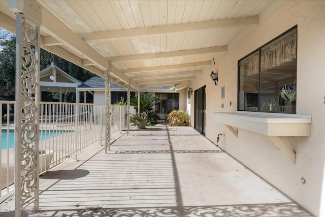 wooden terrace with a fenced in pool and a patio area