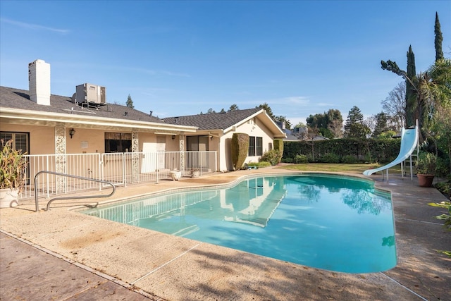 view of pool featuring a patio, a water slide, and central AC