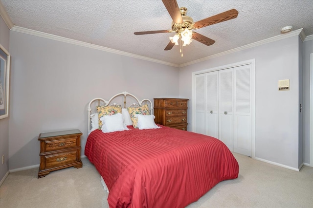 bedroom with ceiling fan, a textured ceiling, light carpet, a closet, and ornamental molding