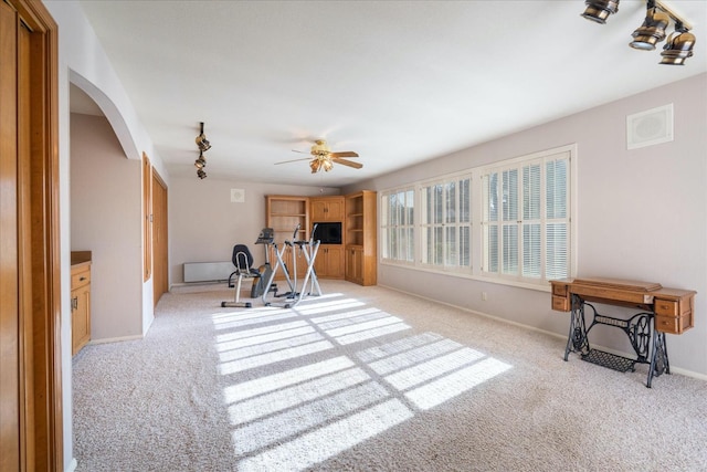 exercise area with ceiling fan and light colored carpet