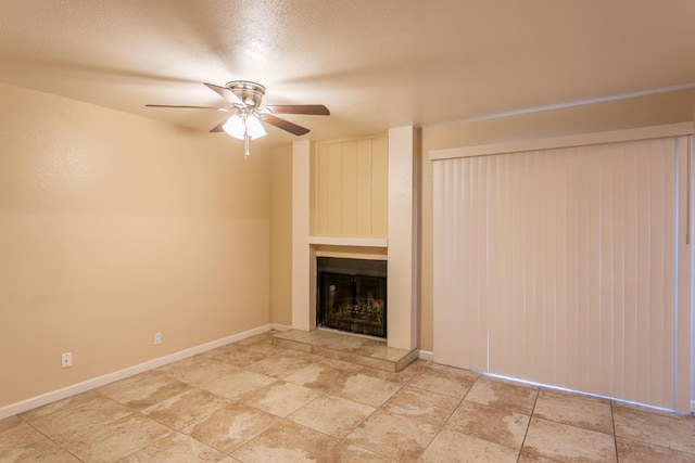 unfurnished living room with ceiling fan and a textured ceiling