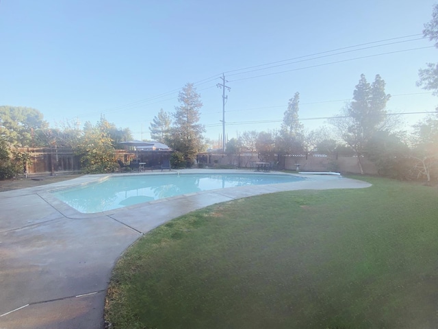 view of swimming pool with a yard