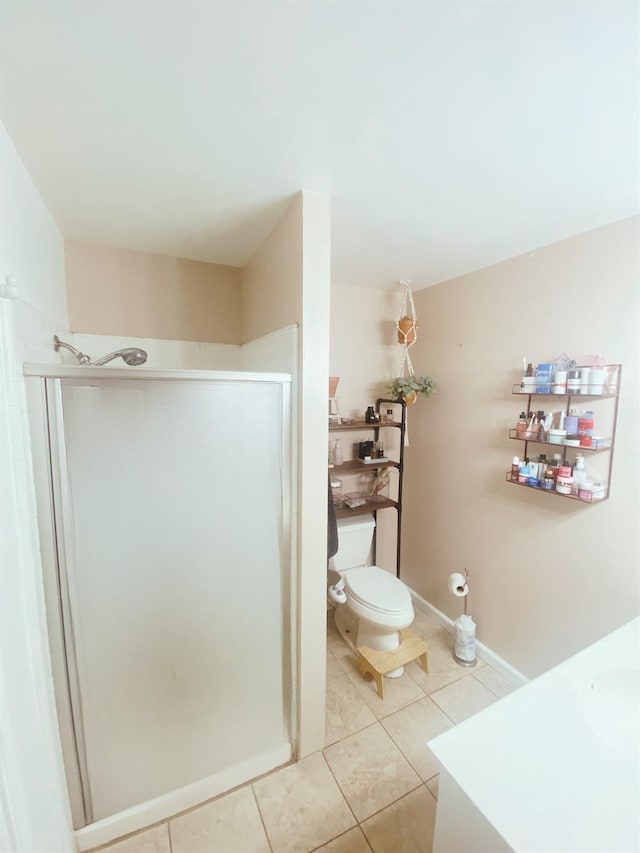 bathroom with tile patterned flooring, toilet, and an enclosed shower