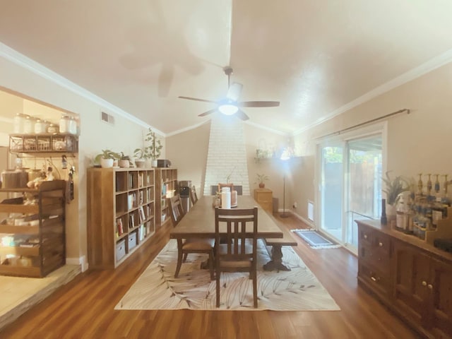 dining space with ceiling fan, wood-type flooring, ornamental molding, and vaulted ceiling