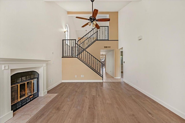 unfurnished living room featuring vaulted ceiling with beams, ceiling fan, and light hardwood / wood-style floors