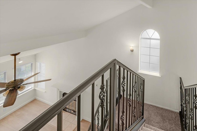 stairway with vaulted ceiling with beams and ceiling fan