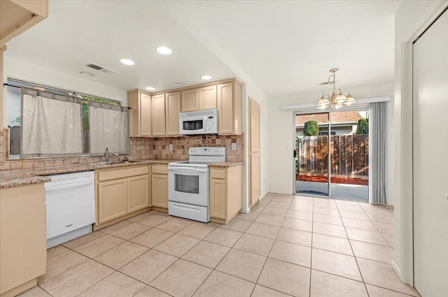 kitchen with tasteful backsplash, white appliances, light tile patterned floors, a notable chandelier, and hanging light fixtures