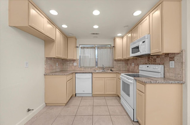 kitchen featuring sink, light stone counters, backsplash, white appliances, and light tile patterned floors