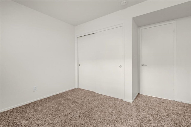 unfurnished bedroom with carpet flooring and a closet