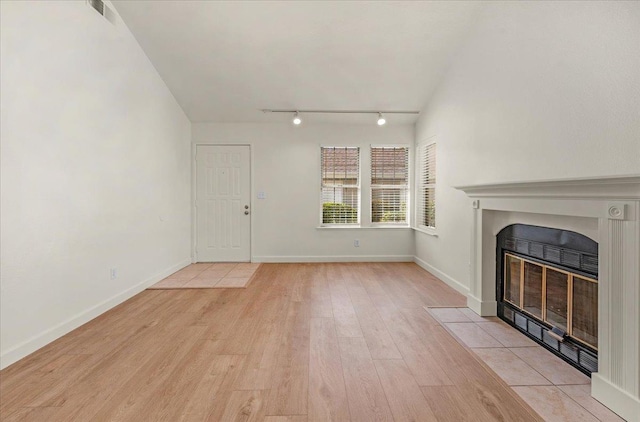 unfurnished living room featuring light wood-type flooring and rail lighting