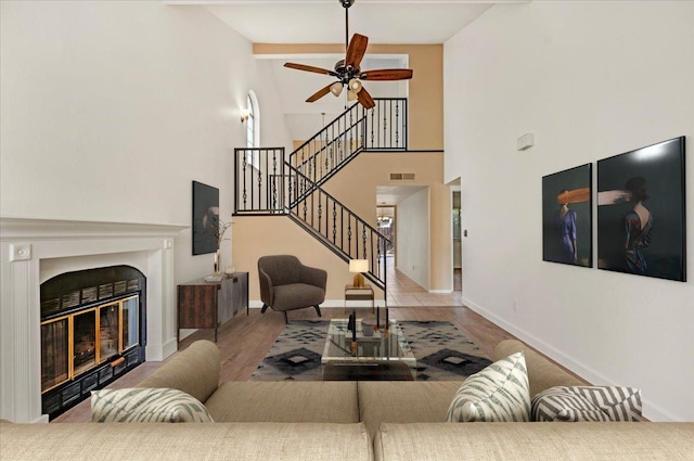 living room featuring ceiling fan, beam ceiling, light wood-type flooring, and high vaulted ceiling