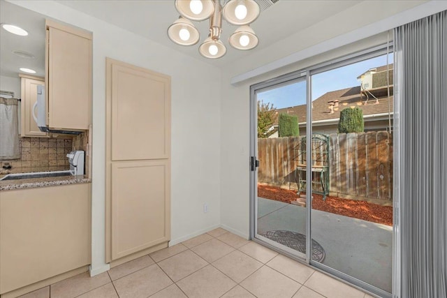 unfurnished dining area with light tile patterned flooring and an inviting chandelier