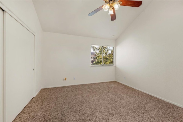 carpeted spare room featuring ceiling fan and vaulted ceiling