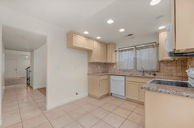 kitchen with backsplash, white appliances, sink, cream cabinets, and light tile patterned floors