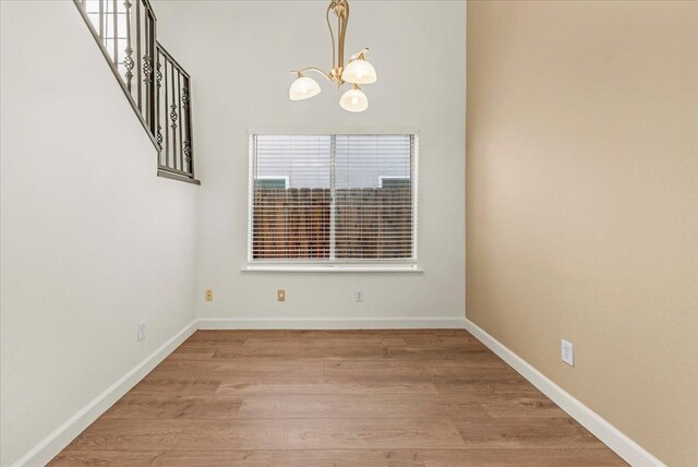 spare room with a chandelier and light hardwood / wood-style floors