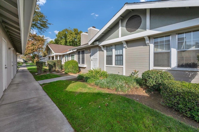 view of side of home with a yard