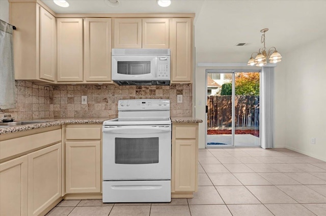 kitchen with a chandelier, white appliances, and cream cabinetry