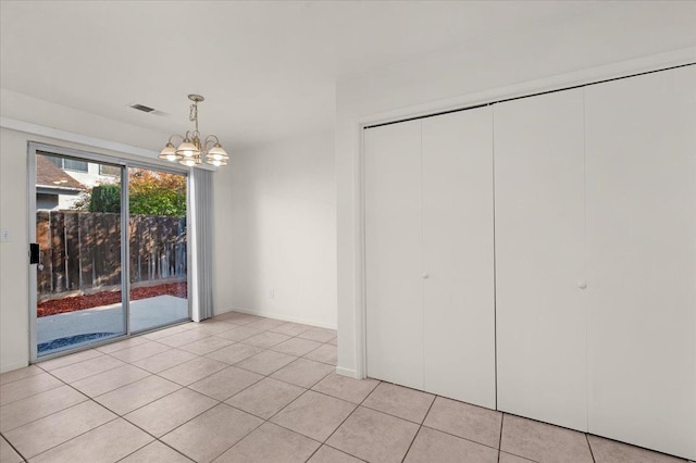 unfurnished dining area with light tile patterned floors and an inviting chandelier