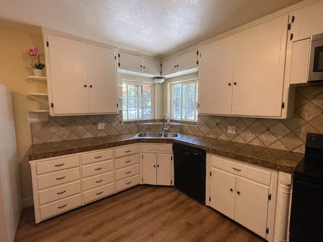 kitchen with decorative backsplash, white cabinetry, sink, and black appliances