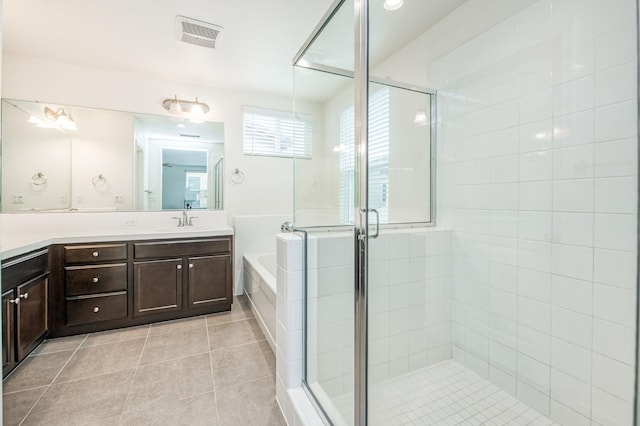 bathroom with tile patterned flooring, vanity, and plus walk in shower