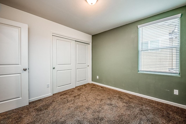 unfurnished bedroom featuring carpet flooring, multiple windows, and a closet