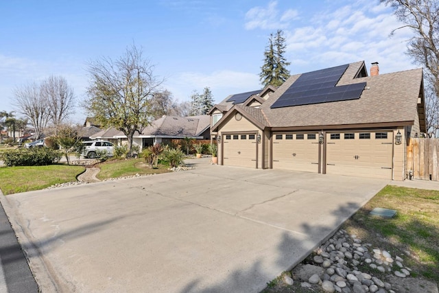 view of side of property with solar panels and a garage