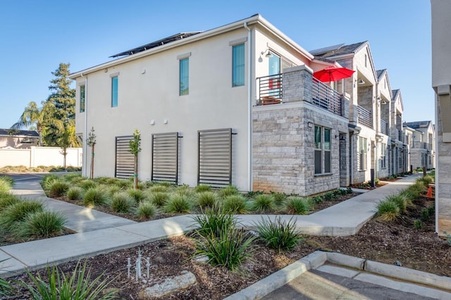 view of home's exterior with a balcony and solar panels