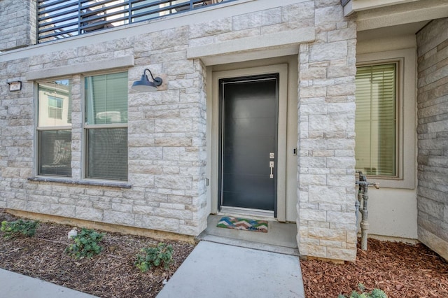 view of exterior entry featuring a balcony