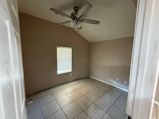 tiled spare room featuring vaulted ceiling and ceiling fan