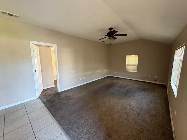 unfurnished room with lofted ceiling, ceiling fan, and light tile patterned flooring