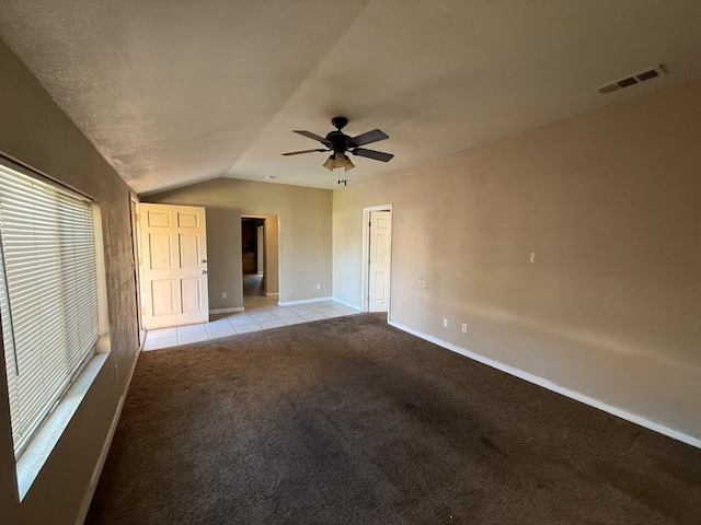 carpeted spare room featuring lofted ceiling and ceiling fan