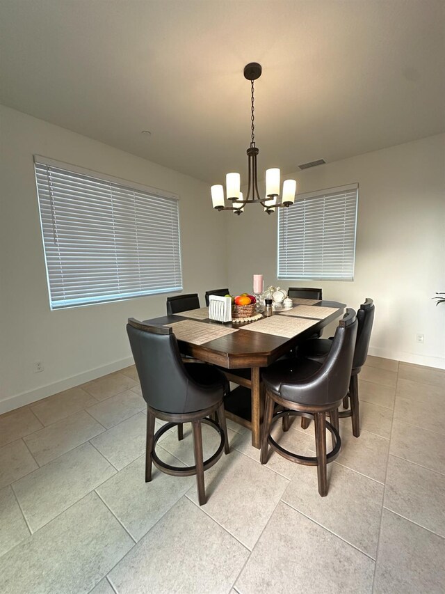 dining area featuring light tile patterned floors and a chandelier